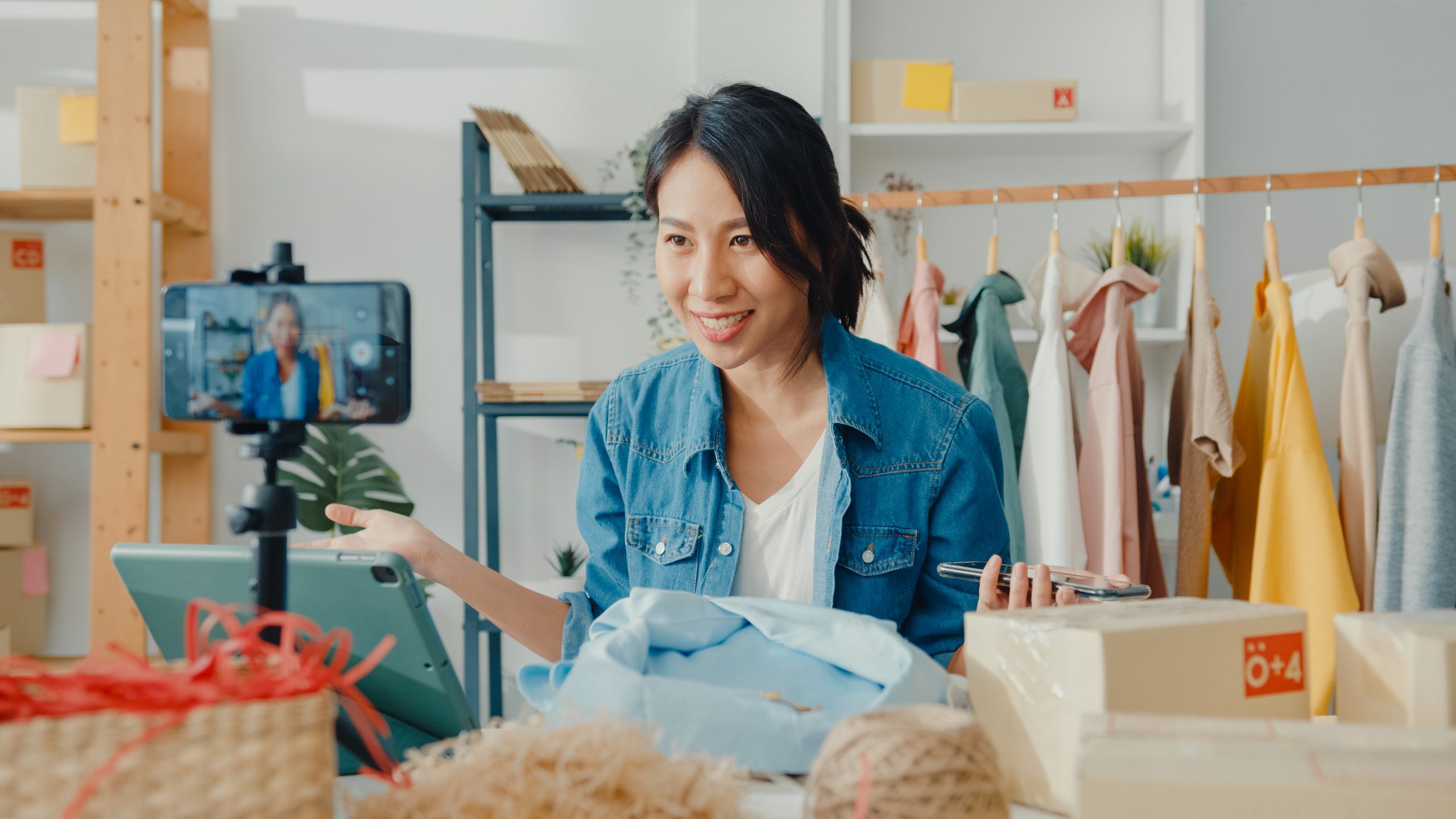Young Asia lady fashion designer using mobile phone receiving pu